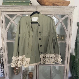 Grön vår/sommar jacka - Säljer nu denna jackan som är slutsåld. Använd en hel sommar och är i fint skick, förutom att de blivit en liten fläck på fickan. Går säkert att tvätta bort men inget jag har tid med att göra just nu. Storlek M men skulle säga att den mer är som en S