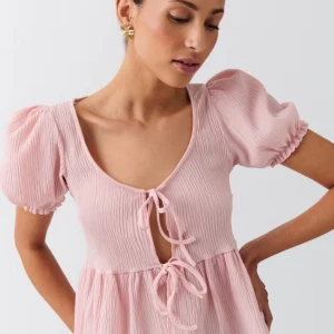 Ljusrosa topp med två knytningar - Söt ljusrosa topp från Gina tricot med puffiga kortärmar och knytning framtill. Perfekt att ha och använda under sommaren. Den är aldrig använd! 💘