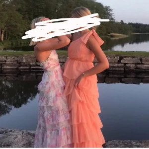 Korallrosa balklänning - Säljer min superfina balklänning med volanger. Den har en oneshoulder-design och är en så fin korallrosa färg. Klänningen är i nytt skick och har en luftig passform som gör den bekväm att bära hela dagen. I strl 38, passar någon med xs-m