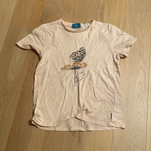 Ljusrosa t-shirt med fjärilstryck - Säljer en ljusrosa t-shirt med ett coolt fjärilstryck och texten 'My Generation Will Save The planet! 🌎💓En har storlek 152.