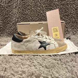 •Golden Goose superstar sneakers vita. Skick 8/10, sparsamt använda! Storlek: 40, fits 40/41. Medföljer. Skorna, original box, dustbag och GGDB kort. Authentic: ✅. Hör av dig vid frågor eller funderingar. Mvh Hessler’s;) 