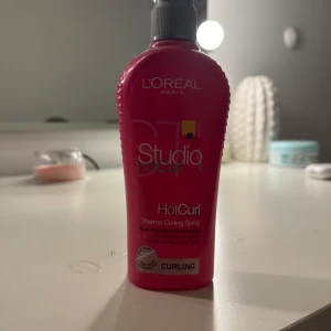 L'Oréal Paris Studio Line Hot Curl - L'Oréal Paris Studio Line Hot Curl är en värmeskyddande spray som hjälper till att forma och hålla lockar. Perfekt för styling med värmeverktyg. Flaskan är rosa och smidig att använda.