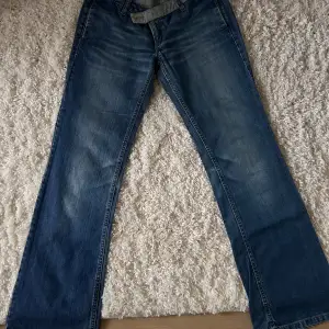 Free Souljeans med snygg detalj i linningen och speciella fickor. Lowwaist och bootcut. Varit väldigt omtyckta men får inte på mig dem längre. Mycket bra skick endast slitning allra längst ner vid foten/skon.