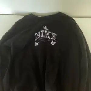 Säljer en svart sweatshirt från Nike med coola fjärilar runt loggan. Perfekt för en avslappnad stil och passar till alla tillfällen. Tröjan är i bra skick och superbekväm. Perfekt för höst och vår!