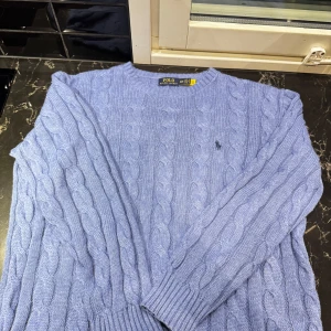 Blå stickad tröja från Ralph Lauren - Säljer en snygg blå stickad tröja från Ralph Lauren. Den har ett klassiskt flätmönster och en liten broderad logga på bröstet. Perfekt för kyliga dagar och ger en stilren look. Passar både till vardags och lite finare tillfällen. 🧶💙 (priset kan diskuteras vid snabb affär)