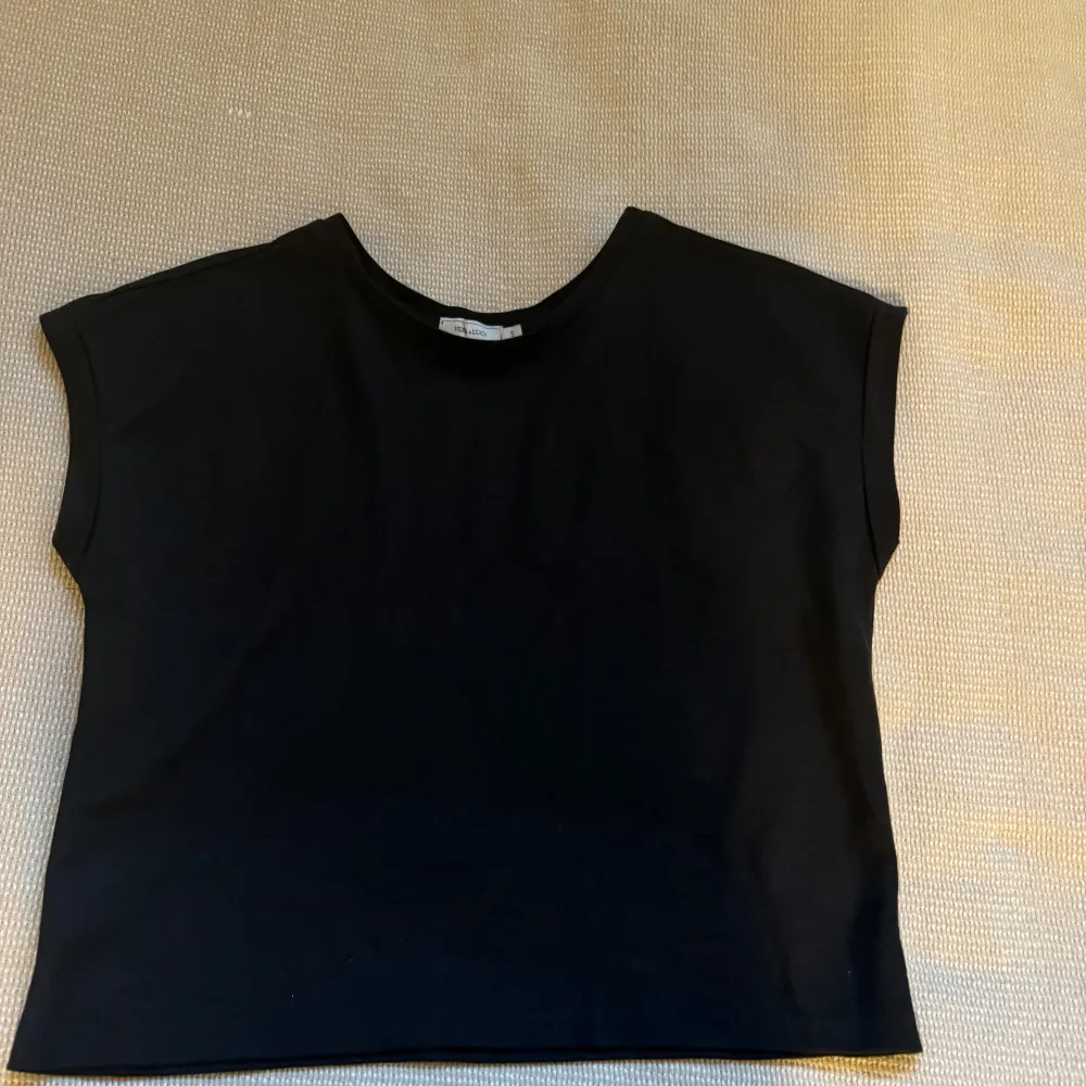Säljer en stilren svart topp från Vera & Lucy i storlek S. Toppen har en enkel design med korta ärmar och rund halsringning. Perfekt för både vardag och festliga tillfällen. Passar bra till jeans eller kjol för en chic look.. Yläosat.