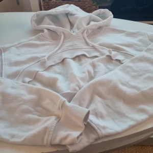 Vit hoodie från H&M - Säljer en supermjuk och bekväm vit hoodie från H&M i storlek XS. Perfekt för mysiga dagar hemma eller en avslappnad dag ute. Den har en klassisk design med en stor huva och ribbade muddar vid ärmslut och nederkant. Passar perfekt till jeans eller leggings!
