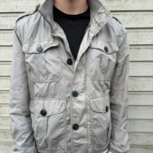Moncler Fieldjacket - En äldre men fräsch fieldjacka från Moncler. Skick runt 7/10 rätt skrynklig men går att fixa enkelt. Storlek 4/L men sitter mer som en M. Kod finns i lappen på insidan så man kan söka upp den på hemsidan. Hör av er vid frågor eller funderingar ✌️