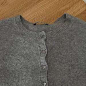 Grå kofta från Stradivarius - Säljer en stilren och mysig grå kofta från Stradivarius. Den är i mycket bra skick och har en klassisk design med knappar framtill. Perfekt för både höst och vår, och funkar lika bra till vardags som till lite finare tillfällen. Superbekväm och lätt att matcha med andra plagg! 💫