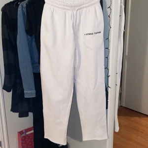 Vita mjukisbyxor från New yorker - Säljer ett par vita mjukisbyxor från new yorker i storlek XS. De har en elastisk midja och texten '@ STRNG TGTHR' tryckt på sidan. De är lite noppriga men absolut inget man tänker på. Säljer då de inte används💕