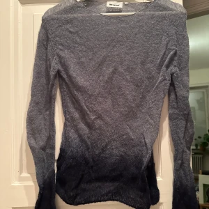 Grå långärmad tröja från Weekday - Säljer en snygg grå tröja från Weekday. Den är långärmad och har en cool ombre-effekt som går från ljusgrå till mörkare nyanser, den är också lite see-through.. Perfekt för både vardag och fest! Tröjan är i bra skick men skrynklig på bild pga legat i en påse länge. Den är lite stretchig 
