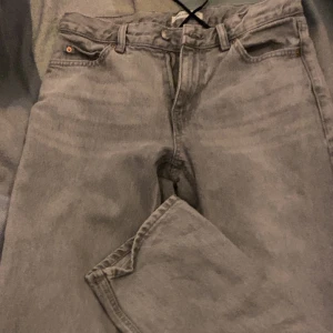 Grå jeans från Gina Tricot - Säljer ett par snygga grå jeans från Gina Tritcot i storlek 34. Har lagt till eget snöre satt man kan spenna åt midjan om man vill, går även att ta bort. Nästan helt oanvända. Ordinarie pris 500 men säljer för 230