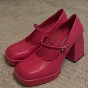Rosa Mary Jane skor från Monki - Säljer ett par supercoola rosa Mary Jane skor från Monki i storlek 37. De har en chunky klack och en söt rem över foten. Perfekta för att liva upp vilken outfit som helst! Använda men i bra skick (remmen visar tecken på lite slitning, men endast på sidan emot huden!!) 💓