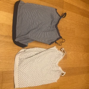 Två somriga linnen - Säljer två linnen i olika mönster. Det ena är randigt i blått och vitt med spetsdetaljer och det andra är prickigt i vitt och svart. Perfekta för sommardagar! Båda har smala  axelband och är i bra skick. 
