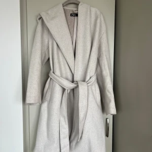 Kappa - Kappa från Zara. Köpt för 1 år sen. Sparsamt använd. Kappan har luva. Beige färg 