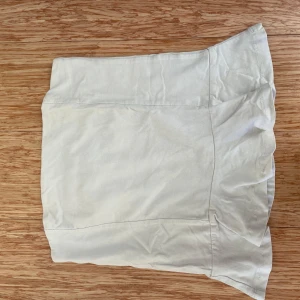Vit peplum topp från Gina Tricot - Säljer en stilren vit peplum topp från Gina Tricot i storlek S. Toppen har en enkel design med en bekväm passform, perfekt för både vardag och fest. Materialet känns mjukt och skönt mot huden. Ett måste i garderoben för en fräsch och somrig look! 🌼