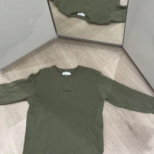 Olivgrön tröja från Les Deux - Säljer en snygg olivgrön tröja från Les Deux i storlek L. Tröjan har en klassisk design med rund hals och långa ärmar. Perfekt för både vardag och lite finare tillfällen. Den är i mycket bra skick och redo för en ny ägare!