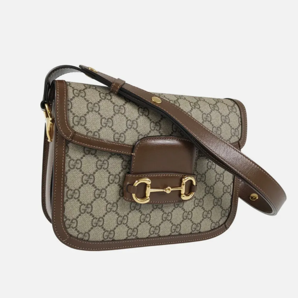 Säljer en snygg Gucci axelväska i brunt och beige med klassiskt GG-mönster. Väskan har guldfärgade detaljer och en praktisk dragkedja inuti. Perfekt för både vardag och fest!. Väskor.