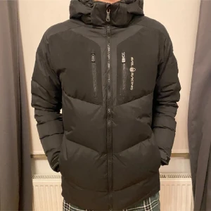 Sail racing vinterjacka - Säljer en svart dunjacka från Sail Racing i mycket bra skick 8/10. Jackan har en stilren design med dragkedja och två praktiska bröstfickor. Perfekt för den svenska vintern💯🥶🥶 Kp för frågor