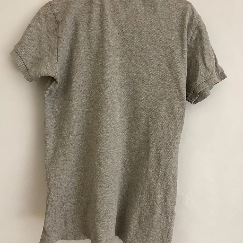 Snygg grå pikétröja från Ralph Lauren med klassisk krage och knappar. Den har en broderad logga på bröstet och är kortärmad. Perfekt för en stilren och avslappnad look. Priset är förhandlingsbart🙌. T-paidat.