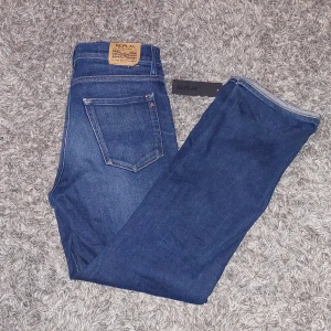 Replay Jeans - Säljer ett par snygga jeans från Replay i ganska bra skick. Det finns en liten defekt på benet och lappen som syns på bilderna men fungerar fortfarande att använda som vanligt. Den har en klassisk femficksdesign som är perfekta i vardagsbruk och kan enkelt matchas med olika outfits. Modell Thad. Tag ingår. Nypris 799kr. Priset är ej hugget i sten. Hör av vid frågor eller funderingar😁