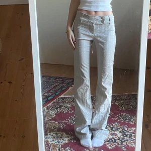 Beige randiga byxor - Midja: ca 36 Innerbensmått: ca 76cm. Säljer dessa snygga beige byxor med vita ränder. Köpt secondhand men är från divided hm. Materialet är väldigt stretchigt