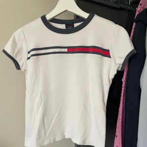 Tommy Hilfiger tröja - Supersnygg tröja från Tommy Hilfiger, passar perfekt till ett par jeans. Lite kortare modell som sitter supersnyggt med ett par lågmidjade jeans. Storlek S men passar mig som har Xs