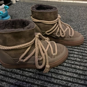 Bruna boots från Inuikii - Snygga bruna boots från Inuikii med varm pälsfoder och grov snörning. Perfekta för kyliga dagar med en stilren design och bekväm passform. Dom är som nya använd tre gånger bara. 