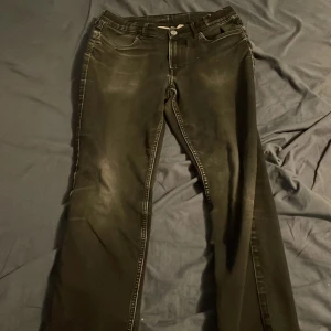 Svarta jeansbyxor - Säljer ett par svarta jeansbyxor med normal passform. Byxorna har en klassisk design med fem fickor och knappgylf. Perfekta för en avslappnad stil.