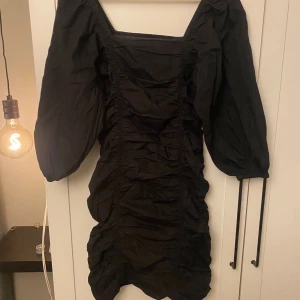 Svart klänning från Vero Moda - Elegant svart klänning från Vero Moda med puffiga långa ärmar och rynkade detaljer. Den sitter väldigt fint på kroppen då den formar sig efter kroppen. Perfekt för dig som inte hittat en nyårsklänning än💕Använd endast fåtal gånger