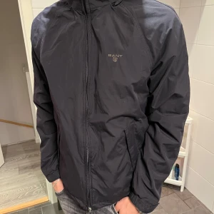 Svart jacka från GANT - Snygg svart jacka från GANT med dragkedja och diskret logga på bröstet. Jackan är i mycket bra skick. .