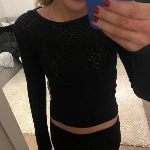Svart topp - Säljer denna svarta toppen ifrån hollister (tror jag). Se detaljer på bild två. Den är använd ett fåtal gånger & därför i superbra skick. Storlek S men skulle säga att den är lite mindre i storleken och därför passar XS-S. 