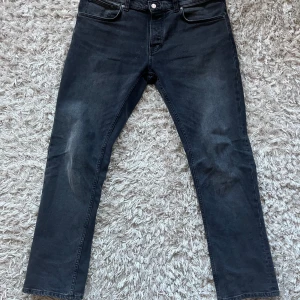 Nudie Jeans - Snygga svarta/gråa jeans med en straight passform. Knappt hunnit använda dem. Säljer pga att dem är lite stora på mig i midjan! Storlek 36/32. Modellen är Grim Tim, ny pris 1600! Mitt pris 799.