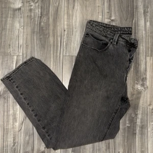 Grå jeans från Abrand Jeans - Snygga mörk grå jeans från Abrand Jeans i en relaxed fit. Perfekta för en avslappnad stil med en klassisk look. jeansen är i bra skick och och har bara förlorat lite färg på knapparna. Annars ser man ingen skillnad. jag säljer jeansen eftersom att de är små är  185 