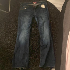 Mörkblå jeans från Fit & Star - Säljer ett par mörkblå jeans från Fit & Star. De har en klassisk femficksdesign och en bootcut-stil. Perfekta för en avslappnad look. De ör lite trasiga längst ner men inget man märker av. Är 167 och de är helt perfekta i längden.