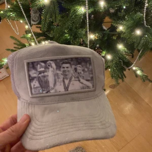 Grå keps från Berretto Sweden - PRIS DISKUTERAS!   Snygg grå keps från Berretto Sweden med ett svartvitt tryck på framsidan. Kepsen har justerbar passform och meshdetaljer för ventilation. Perfekt för en sportig look!