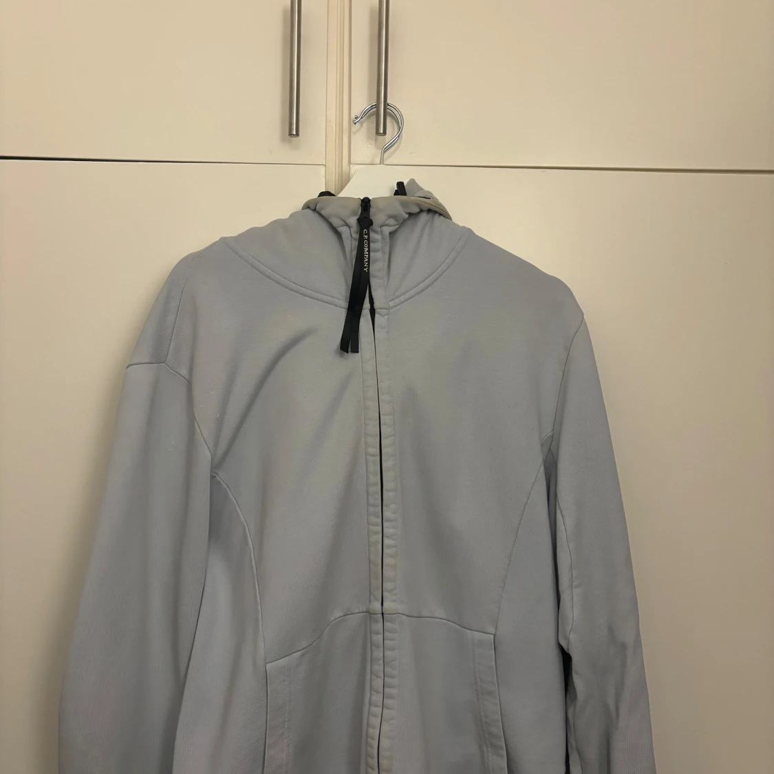 Ljusgrå jacka med huva och glasögondetalj - 90