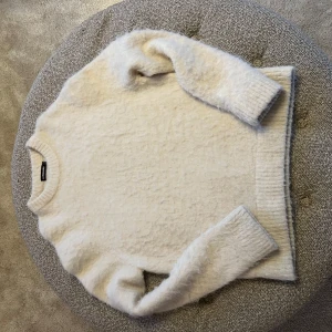 Vit tröja från J.Lindeberg - Mysig vit tröja från J.Lindeberg i ett fluffigt material. Perfekt för kyliga dagar med sin långärmade design och ribbade kanter.