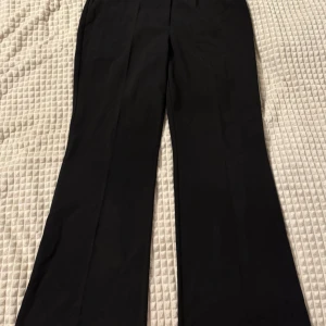 Svarta kostymbyxor - Snygga svarta kostymbyxor med en klassisk design. De har en rak passform och är perfekta för en stilren look. Passar utmärkt till både formella och avslappnade tillfällen.