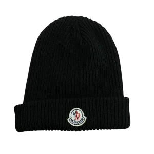 Svart mössa från Moncler - Snygg svart ribbad mössa från Moncler med broderad logotyp framtill. Perfekt för att hålla värmen under kyliga dagar med stil. HELT NY! använd bara 2/3 gånger !!🩵