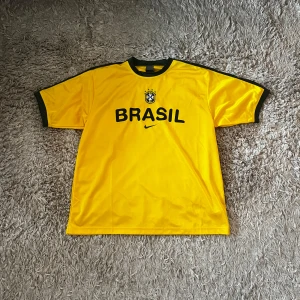 Brasilien träningströja 2002/2003 - Mycket ovanlig Brasilien träningströja från säsongen 2002/2003. Spelare som Ronaldo, Ronaldinho, Rivaldo, Cafu och Roberto Carlos hade tröjan innan sin VM kampanj där laget vann turneringen. Tröjan är såklart äkta, köpt från ClassicFootballShirts i somras. Kvitto finns vid behov. Tröjan är i storlek L men sitter lite oversized - väldigt bra skick, 9/10. Bara att skriva vid funderingar! 🇧🇷 