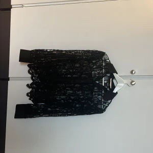 Svart spetsblus från Zara - Snygg svart spetsblus från Zara med långärmad design. Perfekt för en elegant look med sitt genombrutna mönster och stilrena snitt. Passar utmärkt till både jeans och kjol.
