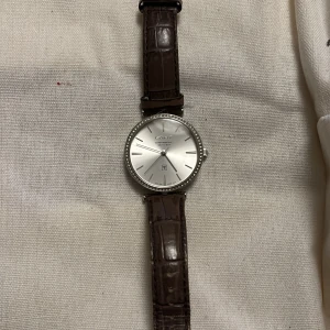 Gant klocka - Gant klocka med brunt läderband. Läderband är i använt skick men själva uret är i fint skick. Dock slut på batteri.