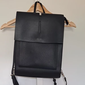 Carin Wester ryggsäck - Väldigt stilren och minimalistisk ryggsäck från Carin Wester. Jag tycker om designen jättemycket, men har insett att mina behov inte ryms i den. Finns plats för en laptop och tillbehör vilket gör den bra för  kontorsarbete. Köpte för 500.