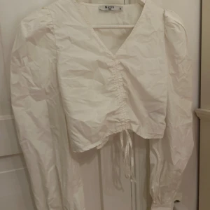 Vit långärmad blus - Vit långärmad blus med dragsko, använt fåtal gånger, fint skick. Köparen står för frakten!