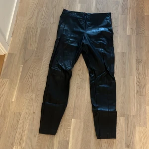 Svarta byxor från Zara Trafaluc Collection - Säljer ett par svarta skinnbyxor från Zara Trafaluc Collection.Byxorna är i storlek L och har en tight passform. Använda fåtal gånger 
