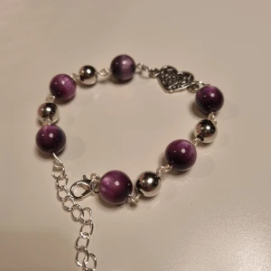 Lila armband med hjärthänge - Gulligt armband i lila färg.  Handgjort.