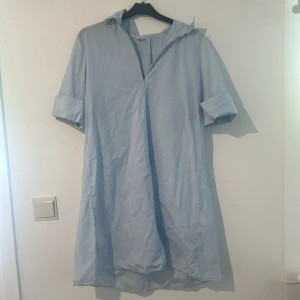 Ljusblå klänning från Monki - Säljer en ljusblå klänning från Arket i storlek 36. Klänningen har en enkel design med en krage och dragkedja framtill. ärmarna går inte att justera🩷Aldrig använd💕