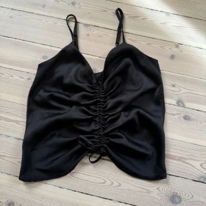 Topp - Svart topp som är justerbar framtill, storlek xs. Mycket bra skick.