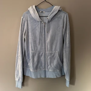 Hoodie - Blå hoodie i materialet velour, med dragkedja. Storlek L